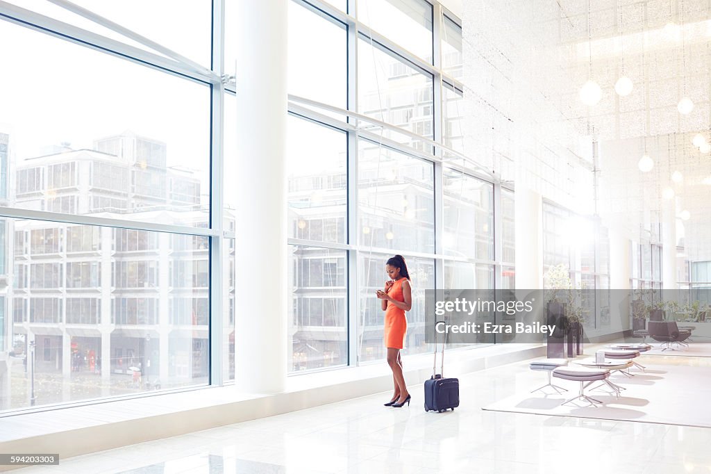 Businesswoman in modern office checking her phone.