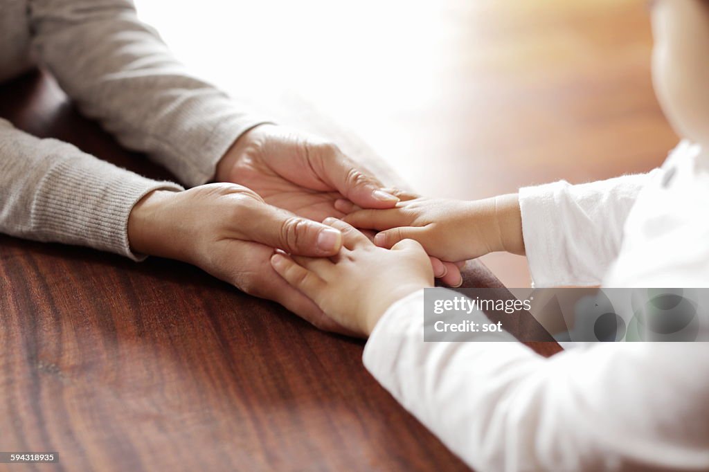 Mother holding baby boy hand,close up