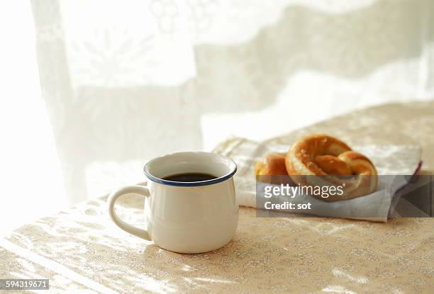 coffee with soft pretzels bread on the table - テーブルクロス ストックフォトと画像