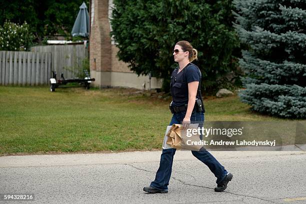 An RCMP officer carries evidence back to a cruiser on Park St. In Strathroy, Ont. On August 11, 2016. Terrorism suspect Aaron Driver, who frequently...