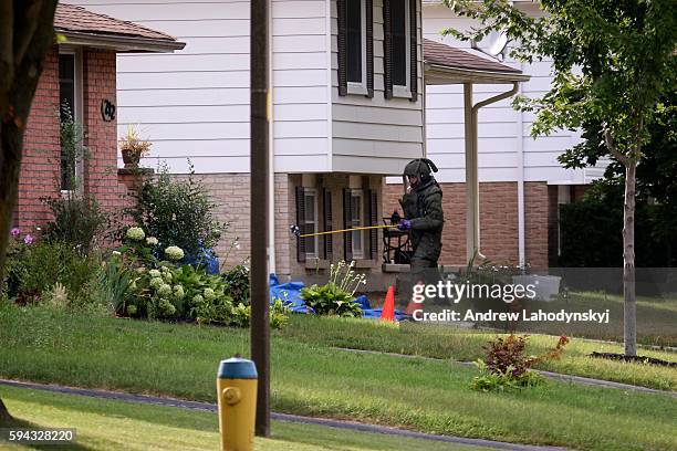 Bomb tech digs through a box from inside the suspects house on Park St. In Strathroy, Ont. On August 11, 2016. Terrorism suspect Aaron Driver, who...