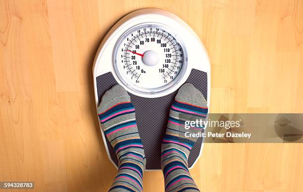 female anorexic weighing herself - weight gain stockfoto's en -beelden