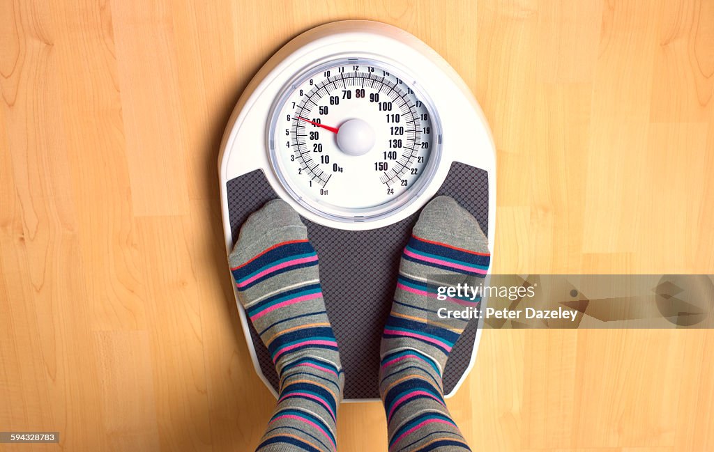 Female anorexic weighing herself