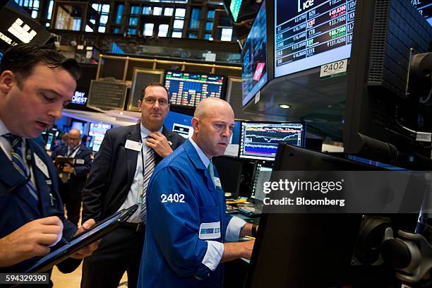 Traders work on the floor of the New York Stock Exchange in New York, U.S., on Monday, Aug. 22, 2016. U.S. Stocks fluctuated after erasing an early...