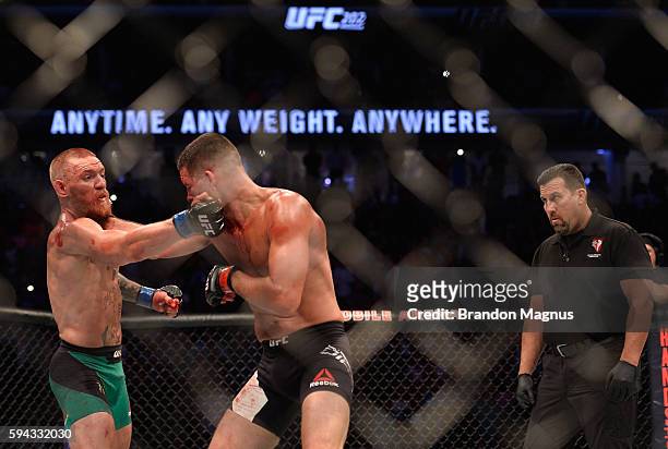 Conor McGregor punches Nate Diaz in their welterweight bout during the UFC 202 event at T-Mobile Arena on August 20, 2016 in Las Vegas, Nevada.