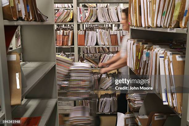 Citizenship and Immigration Services , officer handles folders with immigrants' applications for permanent U.S. Residency in the Dallas Field Office...