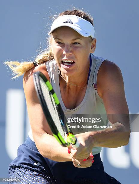 Caroline Wozniacki of Denmark returns a shot to Jelena Ostapenko of Latvia during their match on day 2 of the Connecticut Open at the Connecticut...