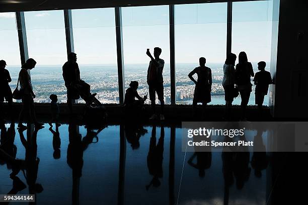 People look out at Manhattan and beyond at One World Observatory at One World Trade Center on August 22, 2016 in New York City.The observation deck...