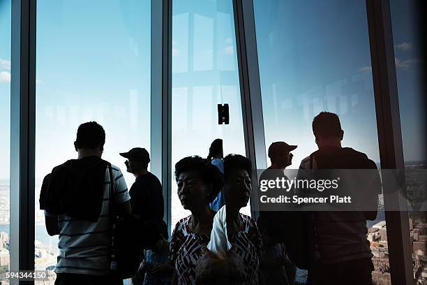 People look out at Manhattan and beyond at One World Observatory at One World Trade Center on August 22, 2016 in New York City.The observation deck...