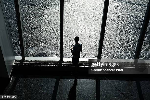 Person looks out at the Hudson River at the One World Observatory at One World Trade Center on August 22, 2016 in New York City.The observation deck...