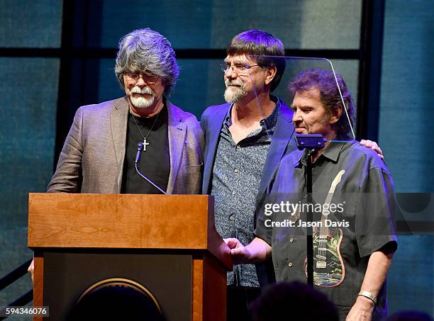 Randy Owen, Teddy Gentry, and Jeff Cook of the band Alabama speak during the debut of the "Alabama: Song of the South" exhibition at Country Music...