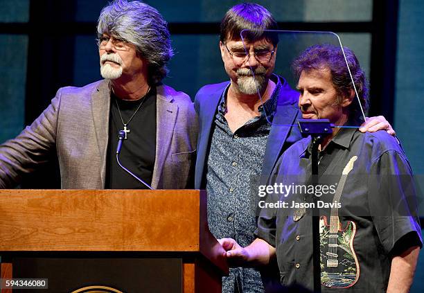 Randy Owen, Teddy Gentry, and Jeff Cook of the band Alabama speak during the debut of the "Alabama: Song of the South" exhibition at Country Music...