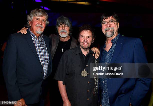 Jackie Owen poses with Randy Owen, Jeff Cook, and Teddy Gentry of the band Alabama attend the debut of the "Alabama: Song of the South" exhibition at...