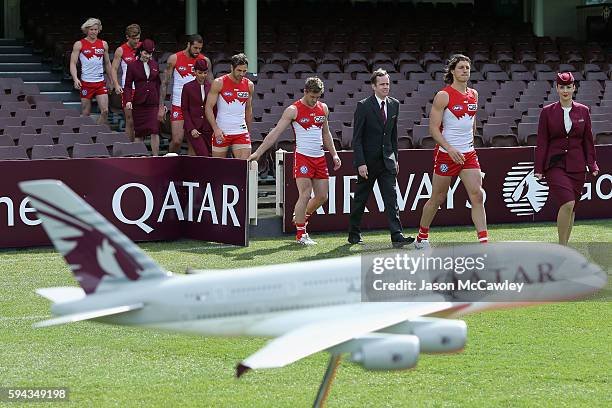 Swans players and Qatar Airways staff make their way onto the field during a Sydney Swans AFL media announcement at Sydney Cricket Ground on August...