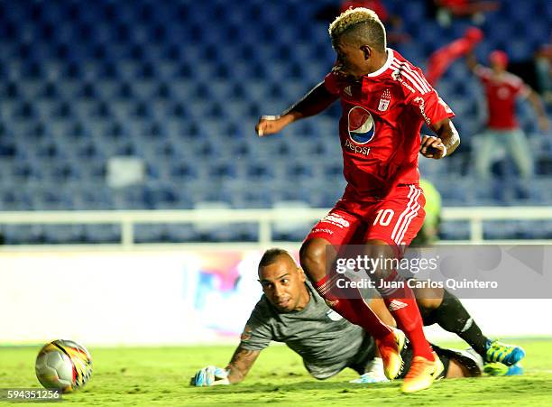 Brayan Angulo of America de Cali dribbles past Carlos Chavez goalkeeper of Atletico FC to score the third goal of his team during a match between...