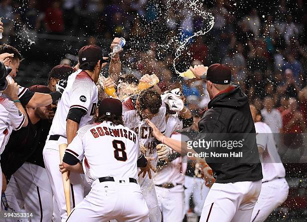 Paul Goldschmidt of the Arizona Diamondbacks is showered with water by teammates at home plate after hitting a walk off home run in the ninth inning...