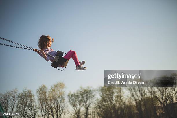 little girl swinging - zwaaien stockfoto's en -beelden