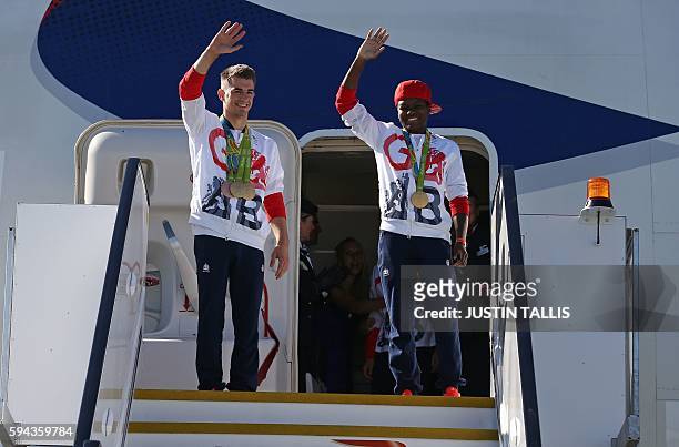 Britain's double gold medal winning gymnast Max Whitlock and Britain's gold medal winning boxer Nicola Adams wave from the top of the steps as...