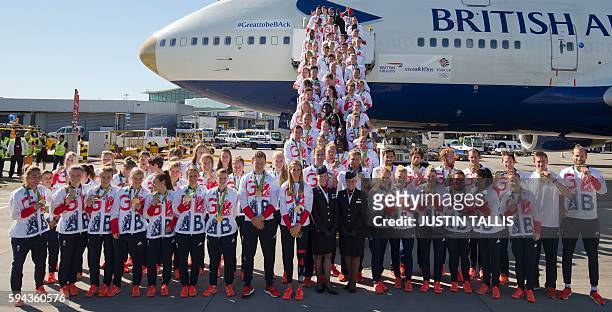 Members of the the British Olympic Team pose for a photograph with their medals after they arrive back from the Rio 2016 Olympic Games in Brazil on a...