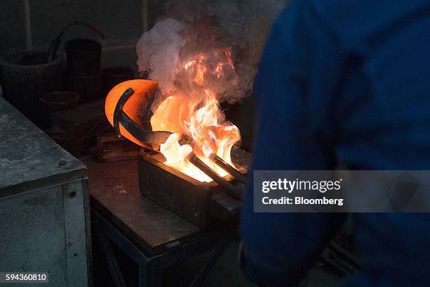 An employee pours gold refined from scrap into a bar mold at the Baird & Co. Ltd. Precious metals refinery in London, U.K., on Wednesday, Aug. 3,...