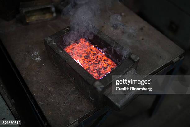 Molten gold, refined from scrap, cools down after being cast into a bar mold at the Baird & Co. Ltd. Precious metals refinery in London, U.K., on...