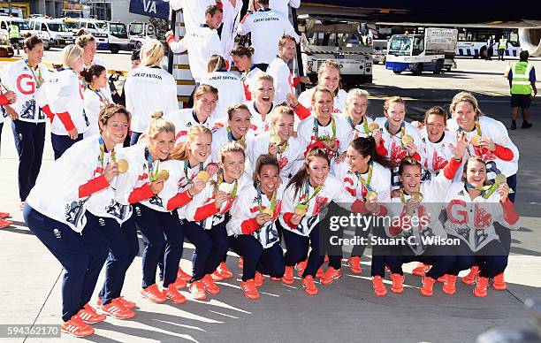 Members of the women's gold medal winning hockey team pose after arriving home at Heathrow Airport on August 23, 2016 in London, England. The 2016...