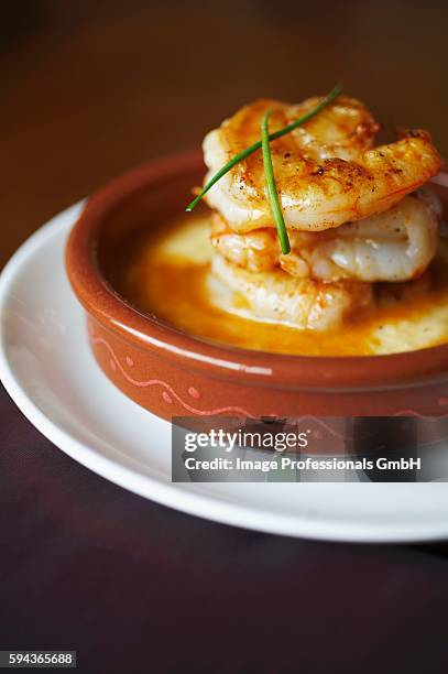 shrimp and grits in a brown dish with chive garnish - shrimp and grits stock-fotos und bilder