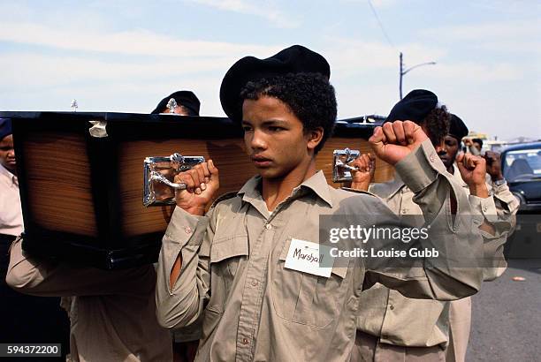 Young Black mourners carry the coffins of 18 Duncan Village apartheid victims shot by police in a political clash, including a baby, at a mass...