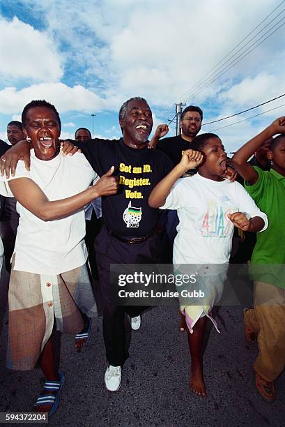 Political supporters walk with Presidential candidate Thabo Mbeki while campaigning in South Africa.