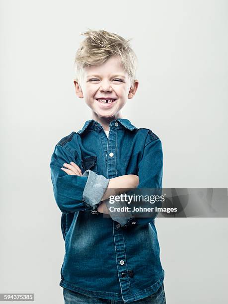 boy with crossed arms - kind zahnlücke stock-fotos und bilder