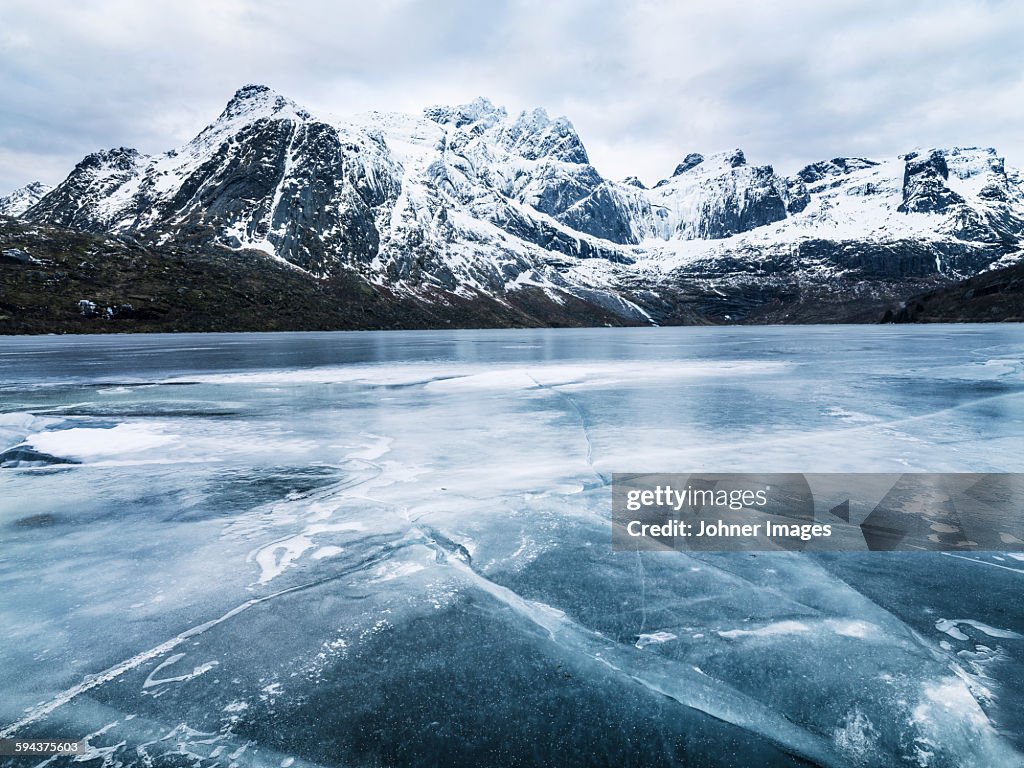 Frozen water and mountain range on background