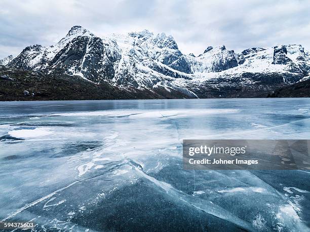 frozen water and mountain range on background - frozen landscape stock pictures, royalty-free photos & images