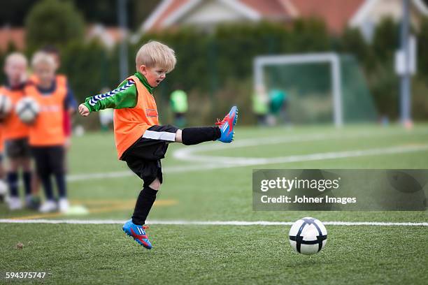 boy playing football - donner un coup de pied photos et images de collection