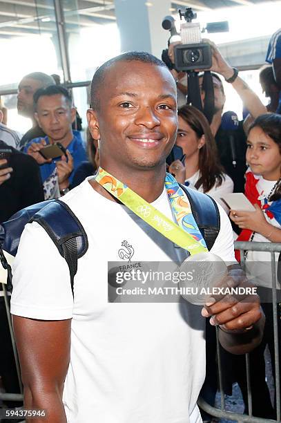 French fiolist and silver medallist Jean-paul Tony Helissey shows his medal at the Roissy-Charles-De-Gaulle airport as he arrives in France with the...