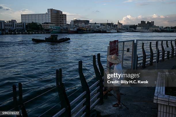 Man fishing at a pier on July 13, 2016 in Kaohsiung, Taiwan. Taiwan, often an overlooked player in the control over the South China Sea, continues...