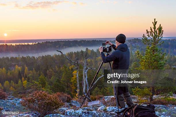 man taking photo of sunset - dalsland stock-fotos und bilder