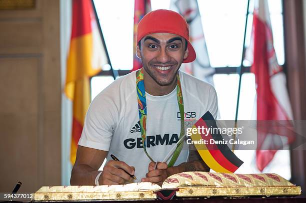 Artem Harutyunyan, bronze medalist boxer signs the golden book of Frankfurt on August 23, 2016 in Frankfurt am Main, Germany.