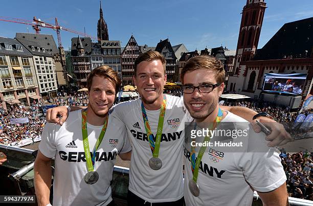 In this handout image provided by DOSB, German olympic athletes Richard Schmidt, Andreas Kuffner and Eric Johannesen pose at the Roemerberg on August...