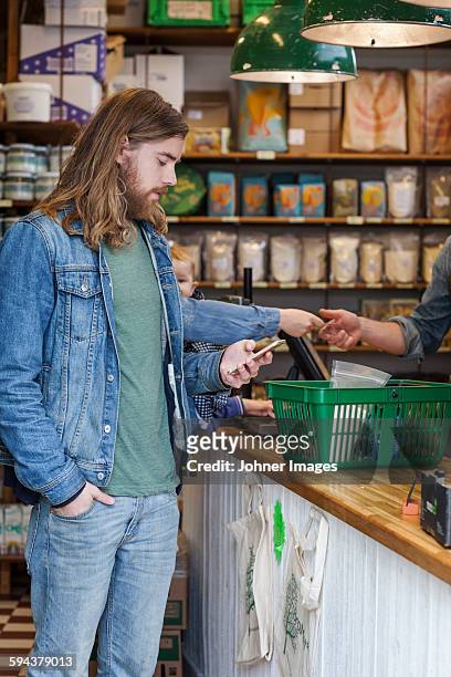 man with cell phone in shop - johner images bildbanksfoton och bilder