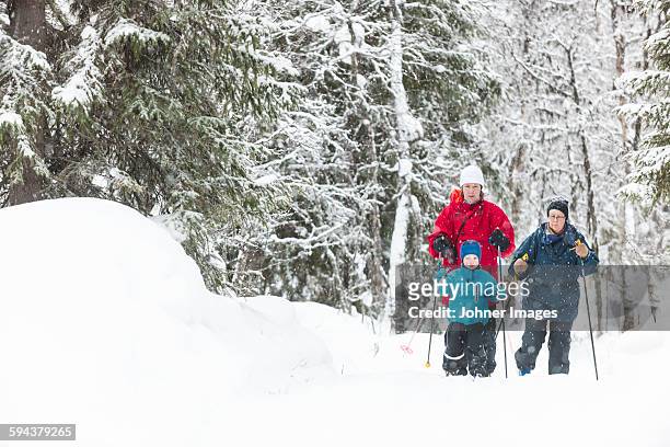 boy skiing with parents - dalarna winter stock-fotos und bilder