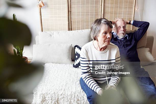 senior couple sitting in living room - real people serious not looking at camera not skiny stock pictures, royalty-free photos & images