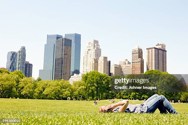 woman in central park with manhattan skyline, new york city, usa - public park usa stock pictures, royalty-free photos & images