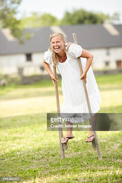 laughing woman walking on stilts - stilt stock pictures, royalty-free photos & images