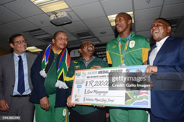 Silver medallist Luvo Manyonga is presented with a cheque at the OR Tambo airport during the arrival of the SA Athletics team from the 2016 Rio...