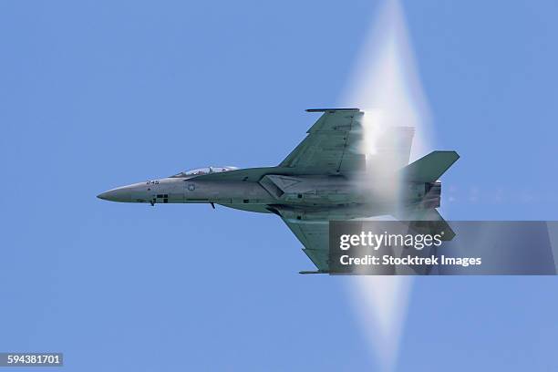 a u.s. navy f/a-18f super hornet flies by at high transonic speed. - schallmauer stock-fotos und bilder