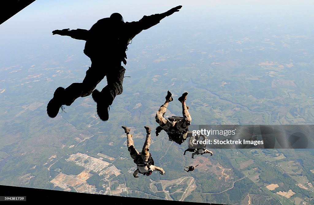 Navy SEALs jump from the ramp of a C-17 Globemaster III over Virginia.