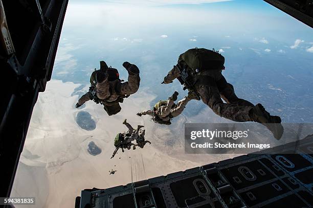 u.s. pararescuemen and u.s. marines jump from a hc-130 over djibouti. - paratrooper stock pictures, royalty-free photos & images