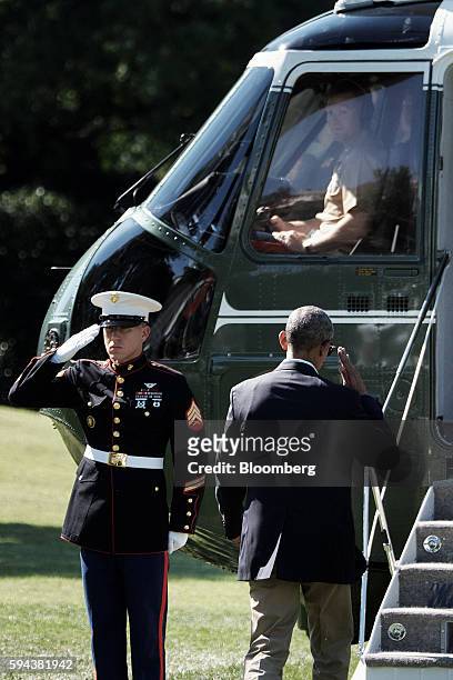 President Barack Obama, right, salutes while walking to Marine One on the South Lawn as he departs from the White House in Washington, D.C. On...