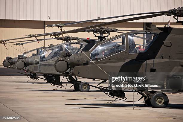 a row of ah-64d apache longbow helicopters at pinal airpark, arizona. - apache helikopter stockfoto's en -beelden