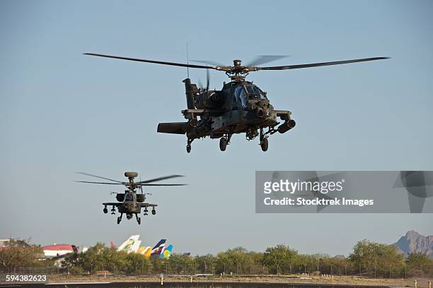 a pair of ah-64d apache longbow helicopters taking off on a mission in support of exercise angel thunder 2013. - ah 64 longbow stock pictures, royalty-free photos & images